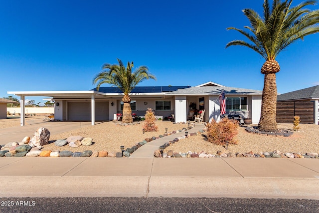 single story home featuring a garage and solar panels