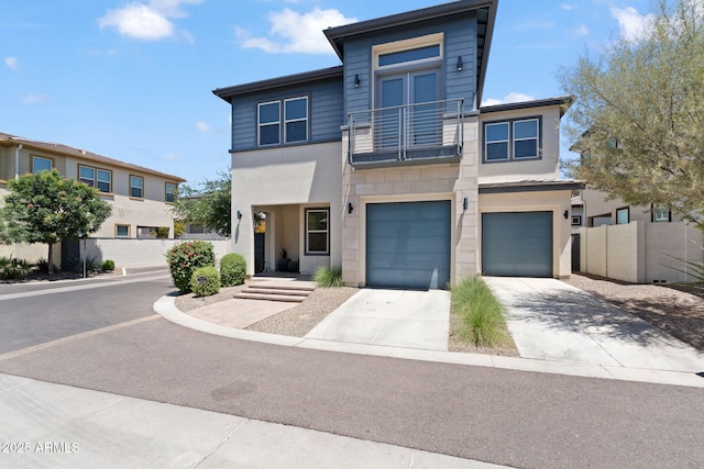 1555 E Ocotillo Rd Unit 16, Phoenix, AZ 85014 - view of front of house with a balcony, driveway, an attached garage, and stucco siding