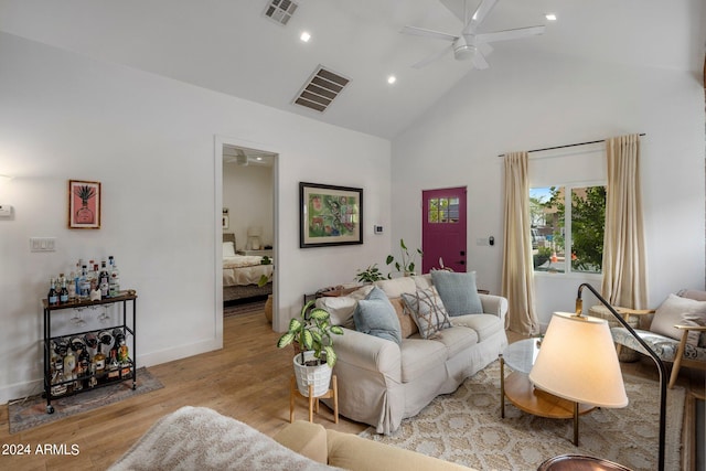 living room featuring high vaulted ceiling, light hardwood / wood-style floors, and ceiling fan