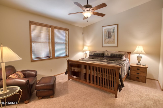 bedroom with a ceiling fan, light colored carpet, vaulted ceiling, and baseboards