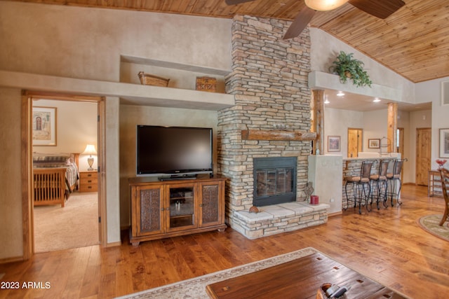 unfurnished living room with a ceiling fan, wooden ceiling, hardwood / wood-style floors, a fireplace, and high vaulted ceiling