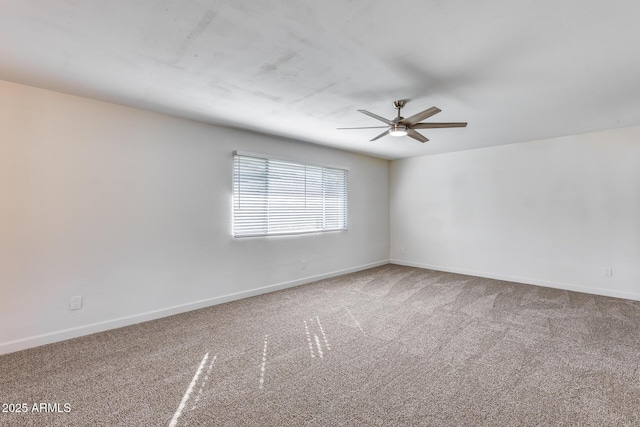 unfurnished room with carpet floors, a ceiling fan, and baseboards