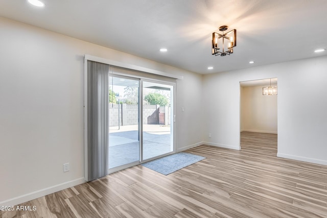 unfurnished room with a chandelier, recessed lighting, light wood-style flooring, and baseboards