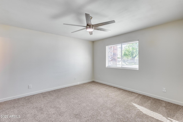 carpeted empty room with ceiling fan and baseboards