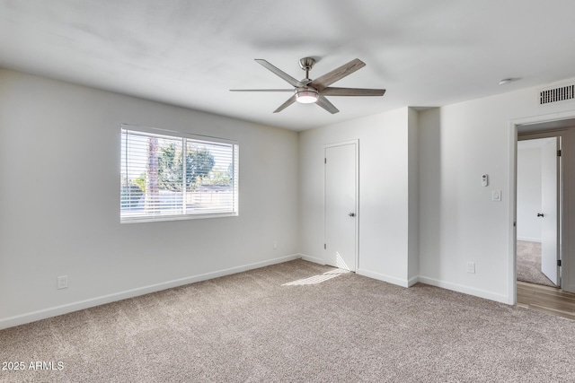 spare room featuring carpet floors, visible vents, baseboards, and a ceiling fan