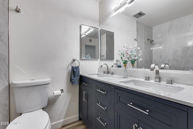 full bathroom with toilet, visible vents, a sink, and tiled shower