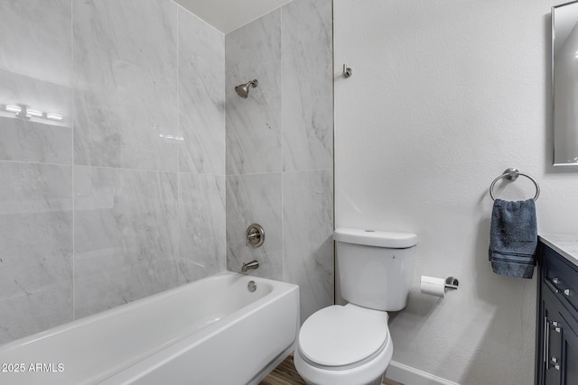 bathroom with toilet, a textured wall, washtub / shower combination, and vanity