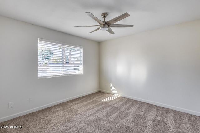 carpeted empty room with baseboards and a ceiling fan