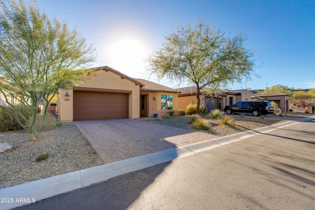 3285 Maverick Dr, Wickenburg, AZ 85390 - view of front of house featuring a garage, decorative driveway, and stucco siding