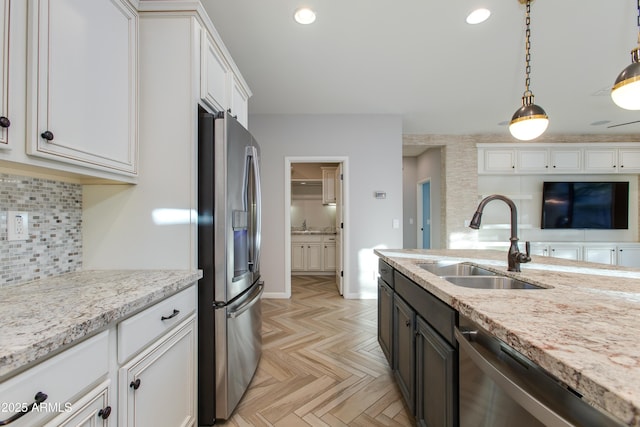 3285 Maverick Dr, Wickenburg, AZ 85390 - kitchen featuring stainless steel appliances, a sink, white cabinetry, decorative light fixtures, and tasteful backsplash