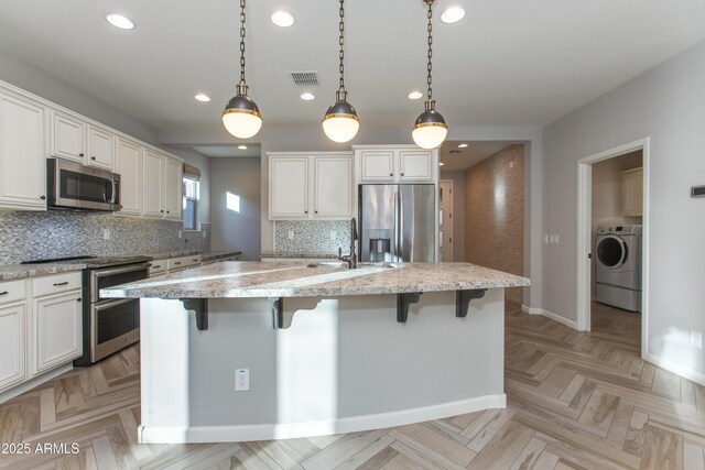 3285 Maverick Dr, Wickenburg, AZ 85390 - kitchen featuring appliances with stainless steel finishes, washer / dryer, recessed lighting, baseboards, and a sink