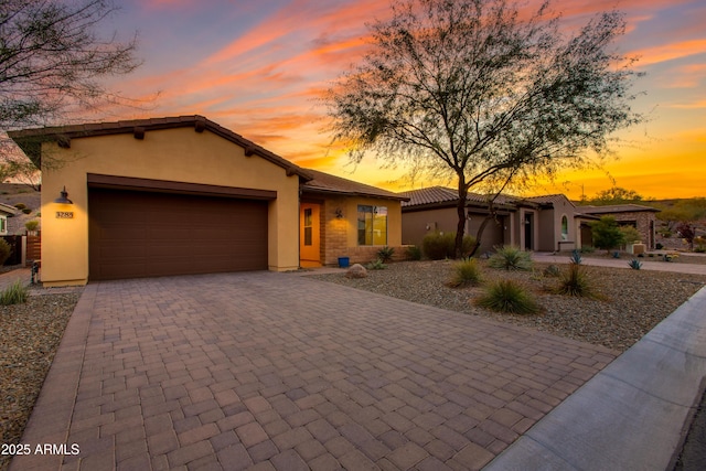 3285 Maverick Dr, Wickenburg, AZ 85390 - view of front of property with an attached garage, stucco siding, and decorative driveway