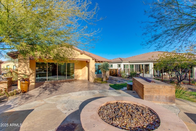 3285 Maverick Dr, Wickenburg, AZ 85390 - rear view of house with stucco siding, a patio area, a tiled roof, and an outdoor fire pit