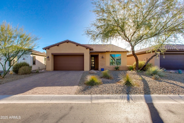 3285 Maverick Dr, Wickenburg, AZ 85390 - view of front of house featuring a garage, decorative driveway, stucco siding, and a tiled roof