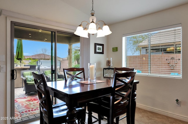 dining area featuring baseboards and an inviting chandelier