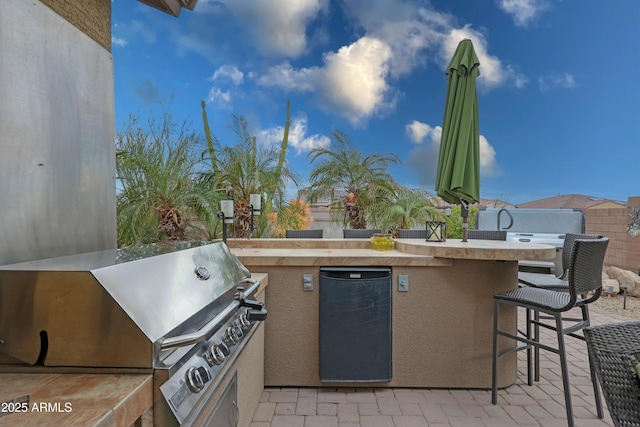 view of patio with outdoor wet bar and area for grilling