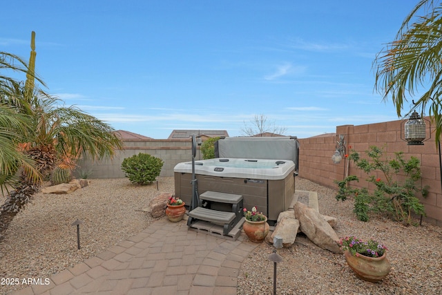 view of patio / terrace featuring a fenced backyard and a hot tub