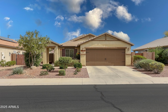 view of front facade featuring concrete driveway, fence, an attached garage, and stucco siding