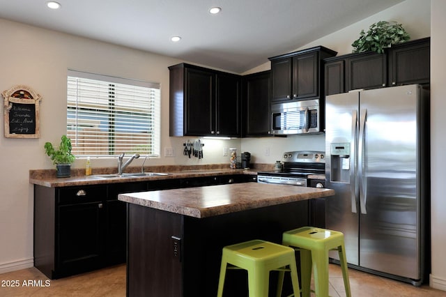 kitchen with light tile patterned floors, stainless steel appliances, recessed lighting, a sink, and a kitchen island