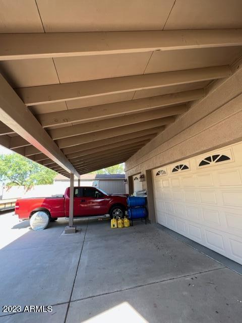 view of car parking featuring a garage and a carport