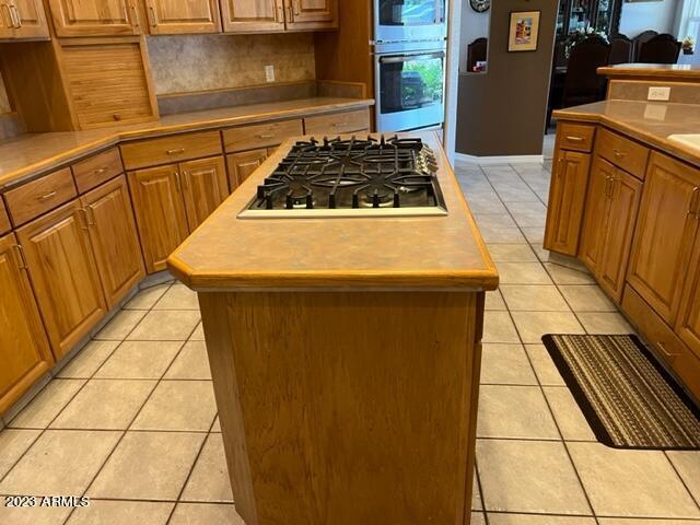 kitchen with stainless steel appliances, light countertops, and a center island