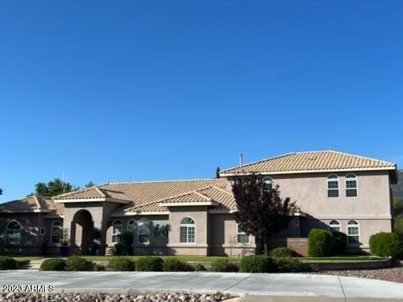 mediterranean / spanish-style home with a tile roof and stucco siding