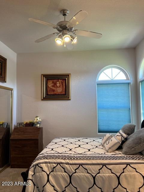 bedroom with ceiling fan and light carpet