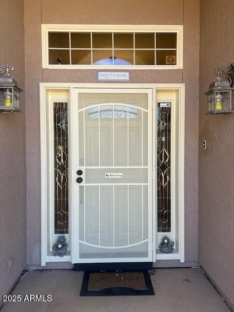 property entrance with stucco siding