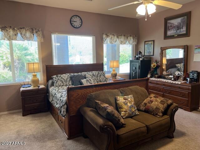 bedroom featuring light carpet and a ceiling fan