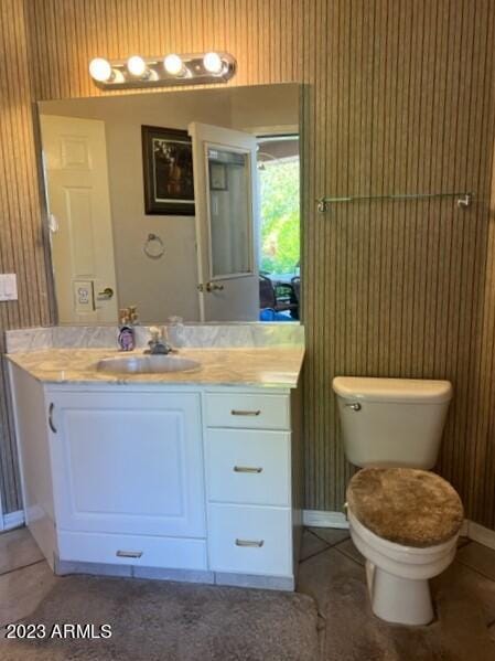 bathroom with baseboards, vanity, toilet, and tile patterned floors