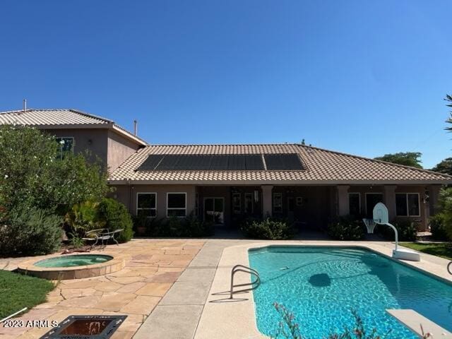 outdoor pool featuring a diving board, a patio area, and an in ground hot tub