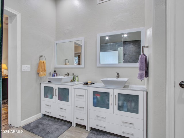 bathroom featuring vanity, hardwood / wood-style flooring, and a shower