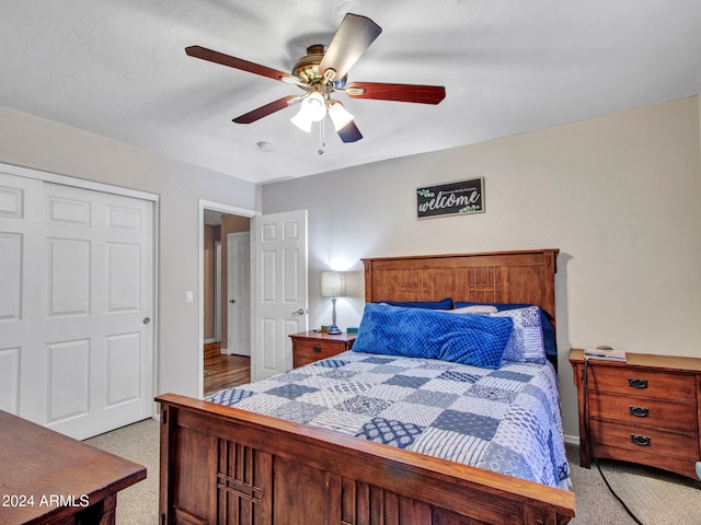 carpeted bedroom with ceiling fan and a closet