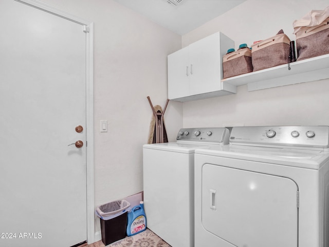 laundry room with independent washer and dryer and cabinets