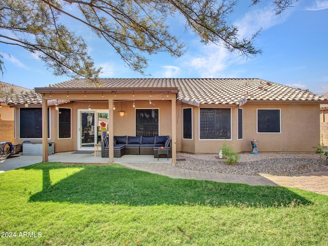 rear view of property featuring a yard, outdoor lounge area, and a patio