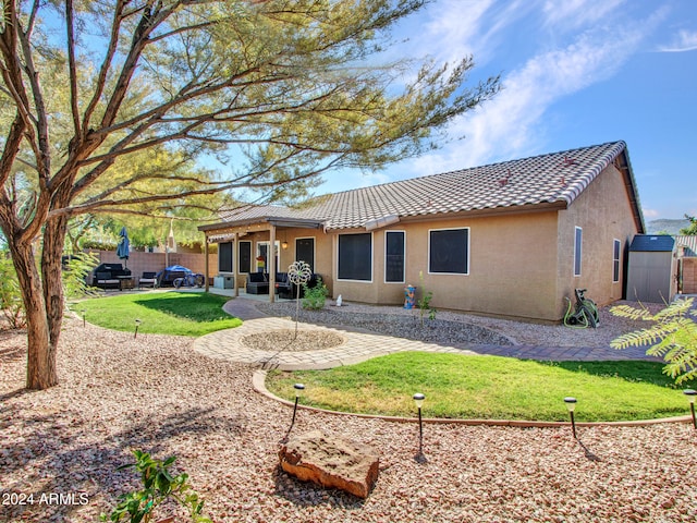 back of property with a patio and a yard