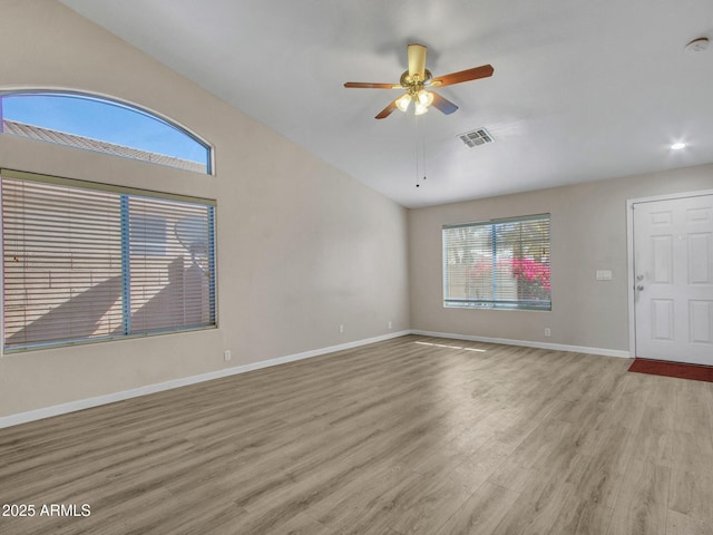 spare room with ceiling fan, plenty of natural light, lofted ceiling, and light wood-type flooring