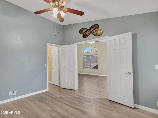 empty room featuring lofted ceiling, light hardwood / wood-style floors, and ceiling fan