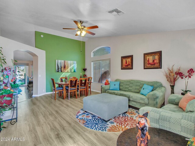 living room featuring vaulted ceiling, ceiling fan, and light hardwood / wood-style flooring