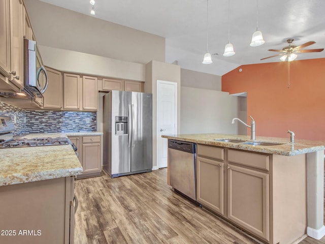 kitchen featuring appliances with stainless steel finishes, sink, a kitchen island with sink, and decorative light fixtures