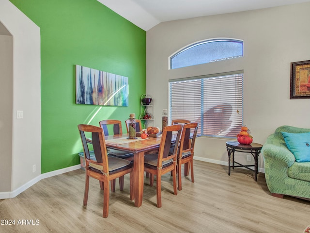 dining space featuring lofted ceiling and light hardwood / wood-style flooring