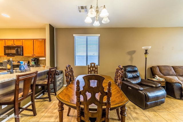 dining room featuring a notable chandelier and light tile patterned flooring