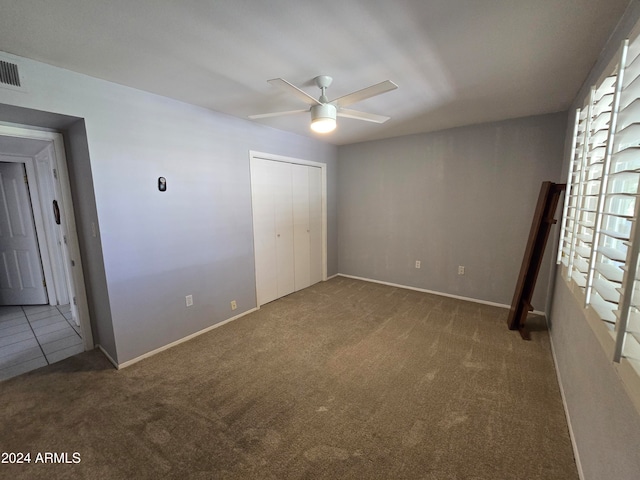 unfurnished bedroom featuring ceiling fan, a closet, and carpet floors