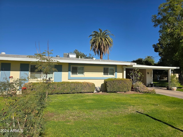 ranch-style home featuring a front lawn and a carport