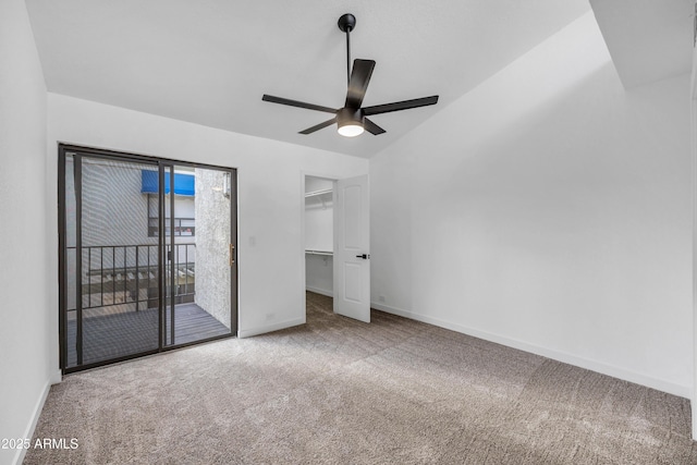 unfurnished bedroom with baseboards, a ceiling fan, carpet, a spacious closet, and access to outside