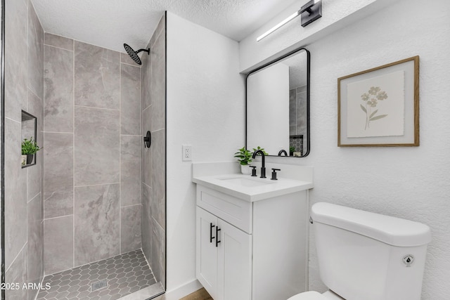 bathroom featuring toilet, a stall shower, a textured ceiling, and vanity