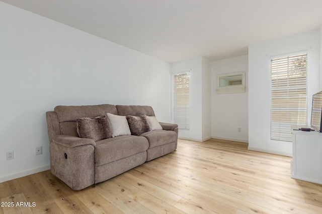 living area featuring light wood-style floors and baseboards