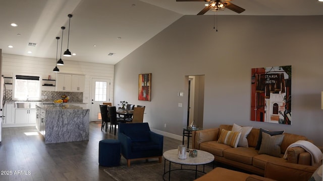 living room with dark hardwood / wood-style flooring, sink, high vaulted ceiling, and ceiling fan