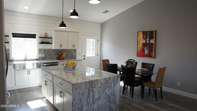 kitchen with a kitchen island, pendant lighting, sink, white cabinets, and dark hardwood / wood-style flooring