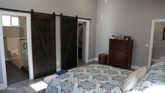 bedroom with wood-type flooring and a barn door